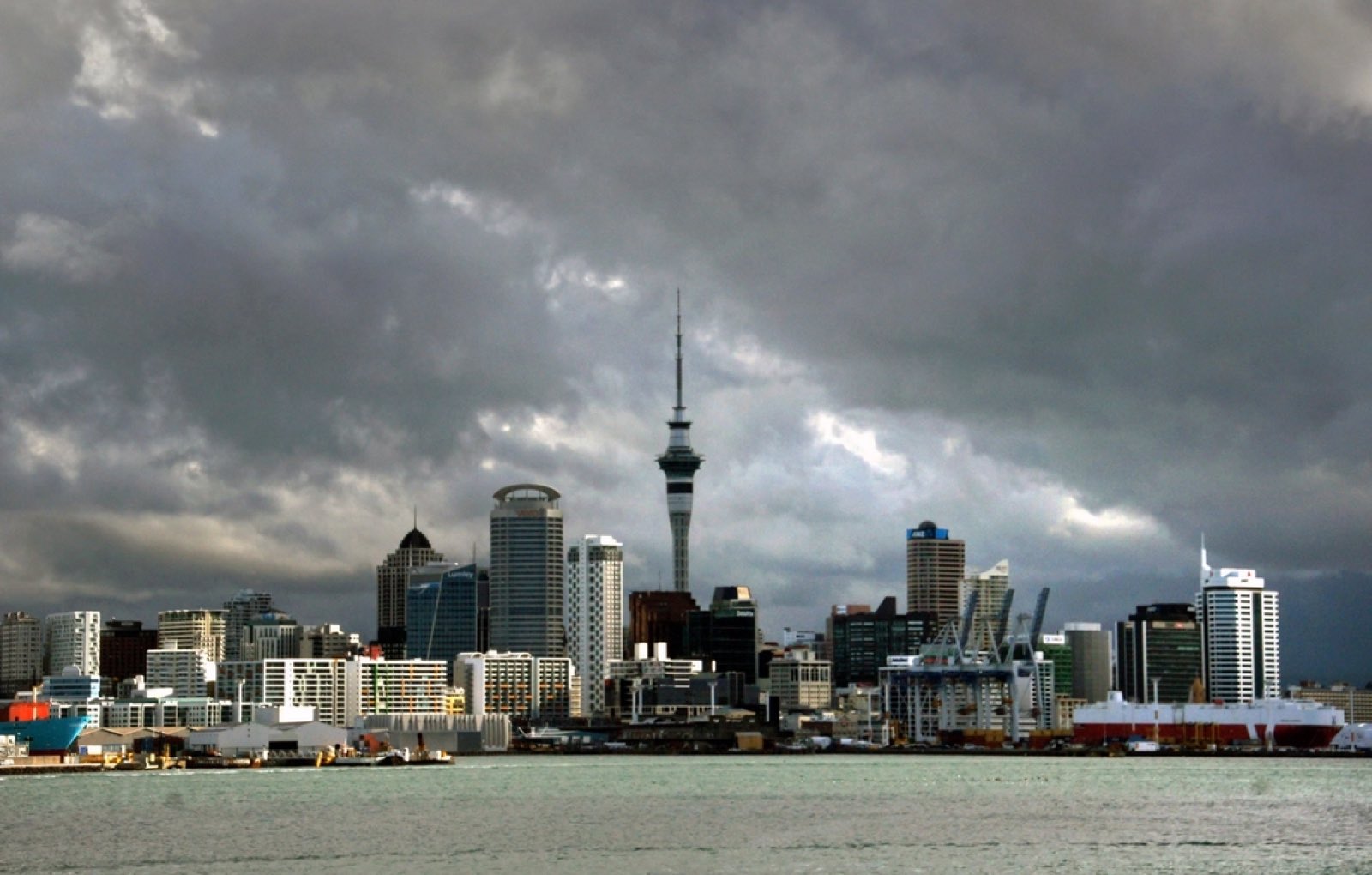 The Auckland skyline and Sky Tower across the harbour under a moody sky